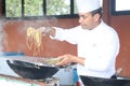 The celebrity chef is preparing exotic Thai noodles on the Chinese wok for a tv show.