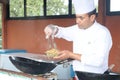 Popular hotel chef is preparing exotic Cantonese noodles on the Chinese wok for a tv show.