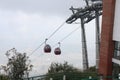 Two cable cars are moving uphill on the wired ropeway full of tourists to visit mountain top on a popular tourist destination. Royalty Free Stock Photo