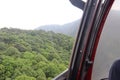 View of the lush green tropical forest from the helicopter window. Hilly terrain of the dense Rainforest of Borneo and Amazon. Royalty Free Stock Photo