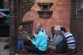 A group of Nepali men singing Hindu bhajan while using holy musical instruments sitting on the ground. Royalty Free Stock Photo