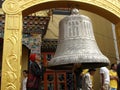 A man prays next to a large bell at the Boudhanath stupa in Kathmandu, Nepal