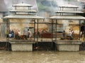 People next to two corpses being cremated on two funeral pyres at the Pashupatinath temple in Kathmandu, Nepal