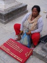 A woman sells coins to tourists to throw into a fountain at Swayambhunath Temple, the monkey temple. Kathmandu, Nepal