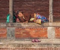 Kathmandu / Nepal - February 2016: Old poor barefoot Hindu woman in bright traditional clothes sleep in sunlight on Kathmandu