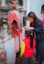 Mother painting a little red dot called tika on the forehead of her child at Boudhanath stupa, Kathmandu, Nepal