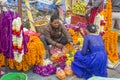A Nepali man sells flowers to a woman in a blue dress, street vendors of bright colorful fresh