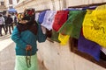 Kathmandu, Nepal - November 22, 2015: Old woman praying around the Boudhanath stupa and turning tibetan prayer wheels Royalty Free Stock Photo