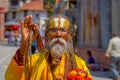 KATHMANDU, NEPAL OCTOBER 15, 2017: Portrait of Nepalese sadhu man holding in his hands a prayer beads on the street of