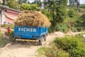 Kathmandu, Nepal - October 29, 2021: Truck overloaded with hay, on a dirt mountain road. Blue lorry on unpaved road in the