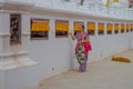 KATHMANDU, NEPAL OCTOBER 15, 2017: Unidentified old woman walking at outdoors near of Boudhanath Stupa building in Royalty Free Stock Photo