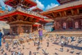 KATHMANDU, NEPAL OCTOBER 15, 2017: Unidentified people standing in the square with a flock of pigeons at Durbar square Royalty Free Stock Photo