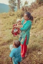 Kathmandu, Nepal - September 22, 2016: Nepalese mother carrying her baby and holding colorful bags in the village, Nepal