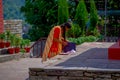 KATHMANDU, NEPAL - SEPTEMBER 04, 2017: Unidentifed women checking her purple purse at outdoors near of Bindabasini