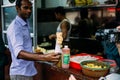 Kati chef sending Chicken Kati Roll to tourist. It is a skewer-roasted kebab wrapped in a paratha bread. Street food in Kolkata.