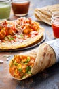 Kati roll with vegies on a table against sauces and other rolls in the background