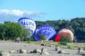 Kaunas, Lithuania 20 10 2022: Three blue and red air balloons on lawn between green trees lying before being fully