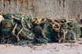 Kavarna, Bulgaria - September 2016: old, torn, turquoise fishing net thrown in a heap with a thick rope