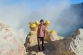 Kawa Ijen Volcano, Banyuwangi, Java Island, Indonesia - 09/09/ 2019: Indonesian sulfur miner is carrying sulfur from the floor of Royalty Free Stock Photo