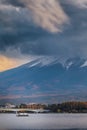 Kawaguchiko Lake in Front of Japanese Fuji Mountain with Bridge and Fishing Boats in Foreground in Japan At Sunset