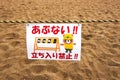 Kawai cute warning sign no trespassing at construction sight with sand pit featuring a Japanese calligraphy and a comic bear