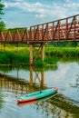 A kayak boat in the lake under a beautiful bridge. Amazing summer landscape without people. Royalty Free Stock Photo