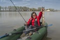 Kayak fishing. Fisher girl holding pike fish trophy on inflatable boat with fishing tackle at lake