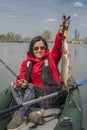 Kayak fishing. Fisher girl holding pike fish trophy on inflatable boat with fishing tackle at lake Royalty Free Stock Photo