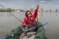 Kayak fishing. Fisher girl holding pike fish trophy on inflatable boat with fishing tackle at lake Royalty Free Stock Photo