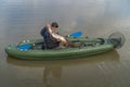 Kayak fishing. Fisherman caught pike fish on inflatable boat with fishing tackle at lake Royalty Free Stock Photo