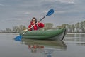 Kayak fishing at lake. Fisherwoman on inflatable boat with fishing tackle