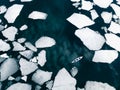 Kayak sailing between ice floes on the lake