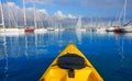 Kayak sailing in a marina port with boats