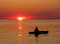 Kayaker on calm water at sunset