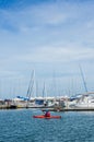 Kayaker paddling past Royal Brighton Yacht Club Marina in Melbourne.