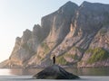 A kayaker stands on a rock at sunset on Bunes beach Royalty Free Stock Photo