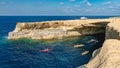 Kayakers and Divers in and around a small cave. Royalty Free Stock Photo