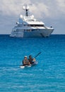 Kayakers on the kayak and a beautiful yacht in the background of clouds on the island of Kefalonia in the Ionian Sea in Greece Royalty Free Stock Photo