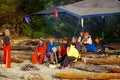 Kayakers sit around the fire listening to the guide