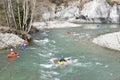 Kayakers on whitewater in Rhine Gorge Ruinaulta in Switzerland. They are manoeuvring with oars to keep balance.