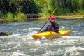 Kayaking along the rough river rapids. Training athlete.