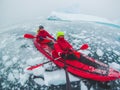 Kayaking in Antarctica, couple of kayakers doing travel selfie with icebergs