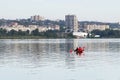Kayaking in the city river with red canoe, kayak boat paddling, process of canoeing