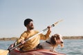 Kayaking with dogs: man rowing a boat on the lake with his spaniel. Royalty Free Stock Photo