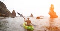 Woman kayak sea. Happy tourist takes sea photo in kayak canoe for memory. Woman traveler poses amidst volcanic mountains Royalty Free Stock Photo