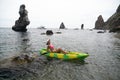 Woman kayak sea. Happy tourist takes sea photo in kayak canoe for memory. Woman traveler poses amidst volcanic mountains Royalty Free Stock Photo