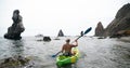 Woman kayak sea. Happy tourist takes sea photo in kayak canoe for memory. Woman traveler poses amidst volcanic mountains Royalty Free Stock Photo