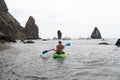 Woman kayak sea. Happy tourist takes sea photo in kayak canoe for memory. Woman traveler poses amidst volcanic mountains Royalty Free Stock Photo