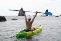 Woman kayak sea. Happy woman kayaks in sea, capturing outdoor memory with happy tourist taking photo. Volcanic mountains Royalty Free Stock Photo