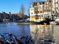 Kayaks on Amstel river in central Amsterdam and parked bicycles by the canal side Royalty Free Stock Photo